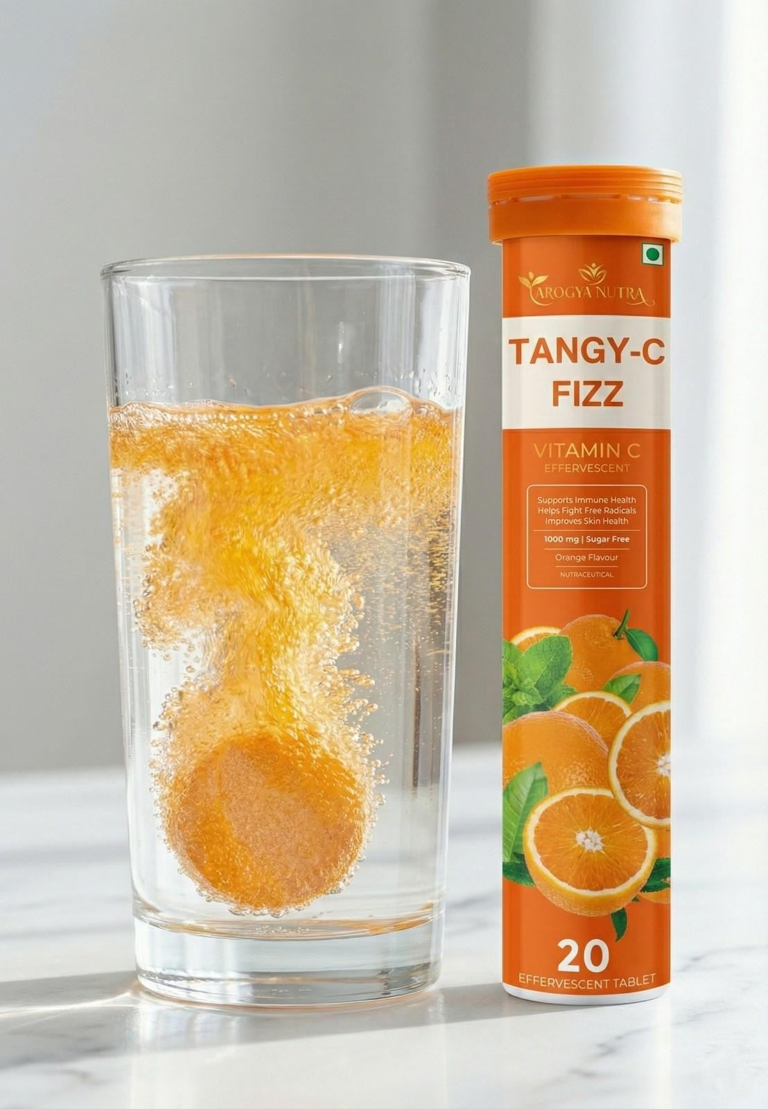 Tangy-C Fizz supplement tube with a glass of orange-flavored drink on a light background