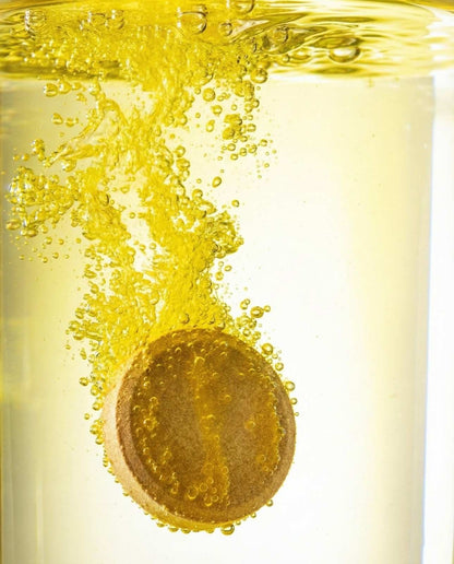 Gold coin with bubbles in a yellow liquid